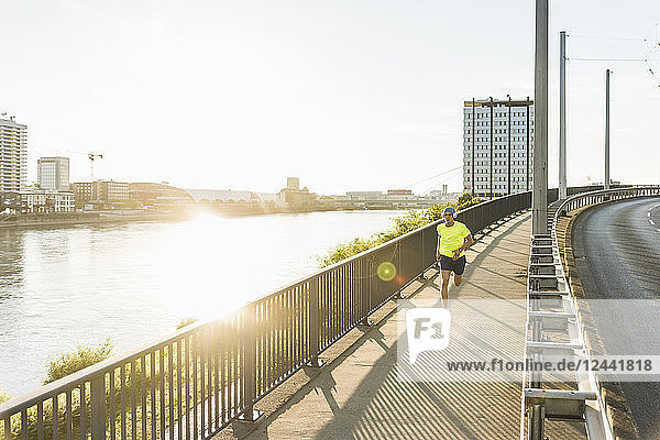 Young athlete jogging on a bridge in the city