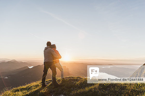 Austria  Salzkammergut  Couple standing on mountain summit  enjoying the view