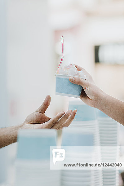 Handing over of roll of ice in an ice cream shop