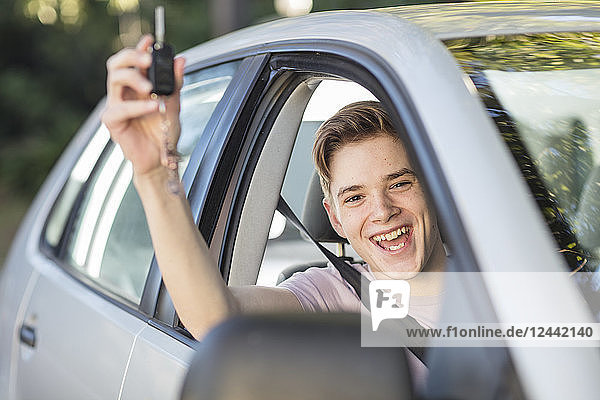 Happy learner driver cheering and holding car key