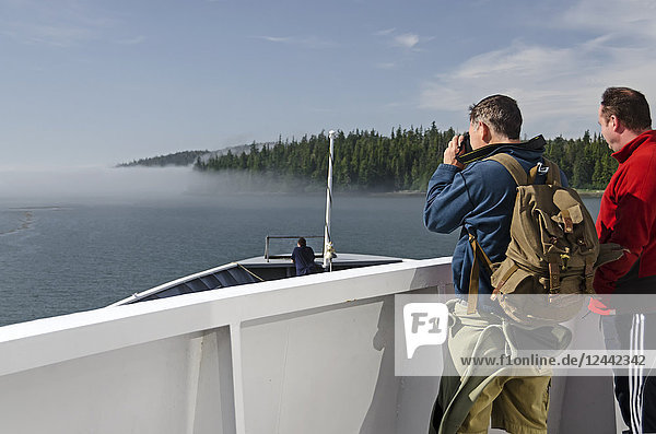 Zwei Touristen beobachten die Annäherung der Alaska State Ferry an die Nebelbank in der Nähe des Eingangs der Sumner Strait von Wrangell Narrows  Südost-Alaska; Alaska  Vereinigte Staaten von Amerika