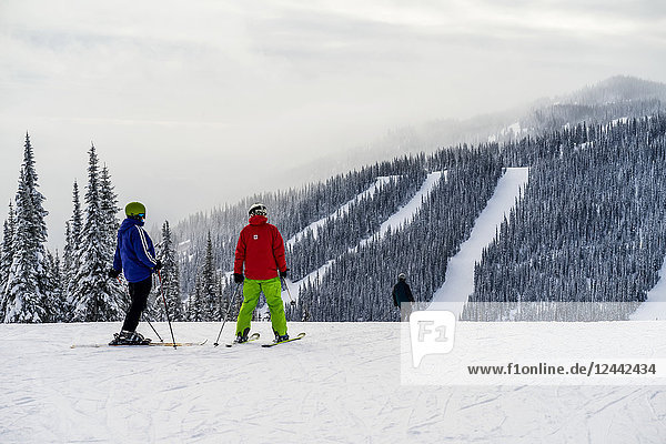 Skiers on a run at Sun Peaks ski resort; Kamloops British Columbia Canada