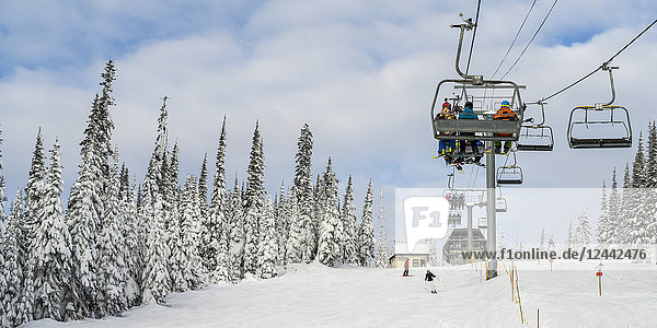 Skiers on a chairlift at Sun Peaks ski resort; Kamloops British Columbia Canada