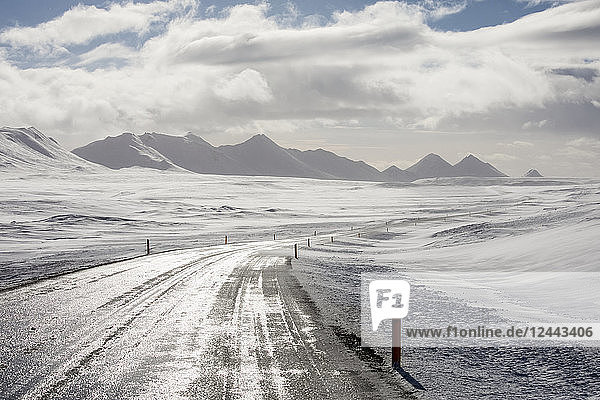 The Ring Road in Iceland goes off into the distance through the snowy North Iceland landscape Iceland