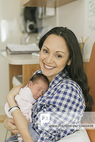 Newborn baby in mother's arms in the Neonatal Intensive Care Unit; Surrey  British Columbia  Canada