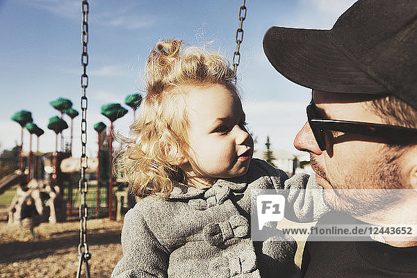 Ein süßes kleines Mädchen mit ihrem Vater nach dem Spielen auf einem Spielplatz während der Herbstsaison  Spruce Grove  Alberta  Kanada