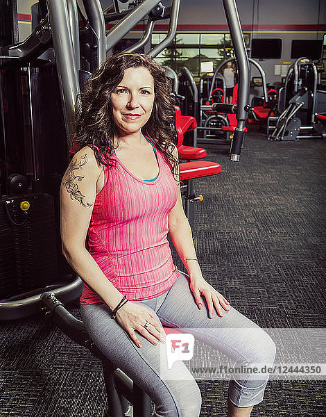 Eine Frau mittleren Alters  die in einem Fitnessstudio trainiert und dabei für die Kamera posiert  Spruce Grove  Alberta  Kanada