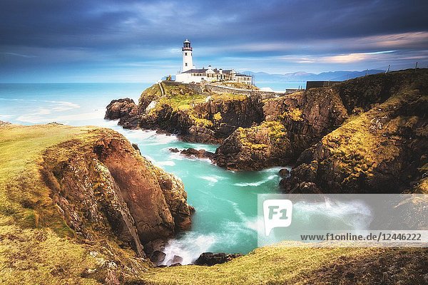 .Fanad Head (Fánaid) lighthouse County Donegal Ulster region Ireland Europe. A photographer on the field at sunrise near Fanad Head lighthouse