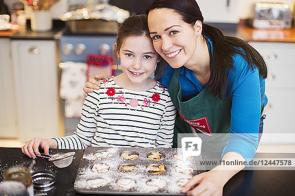 Portrait lächelnde Mutter und Tochter beim Backen in der Küche