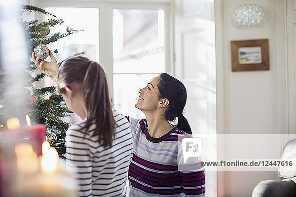 Mutter und Tochter schmücken den Weihnachtsbaum