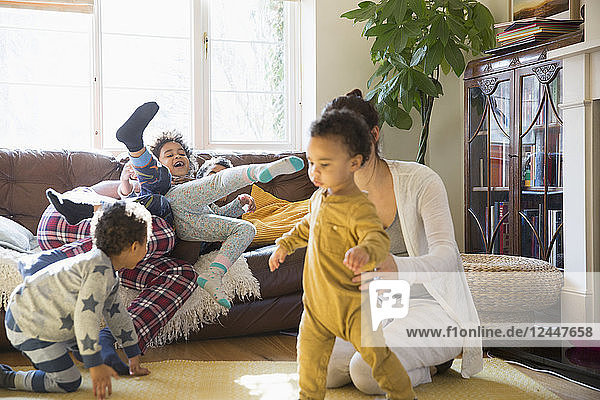 Junge Familie in Pyjamas spielt im Wohnzimmer