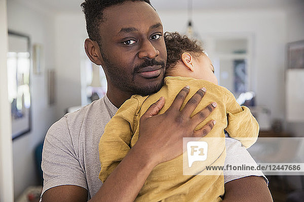 Porträt liebevoller Vater hält müden Babysohn