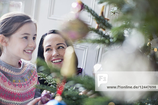 Happy mother and daughter decorating Christmas tree