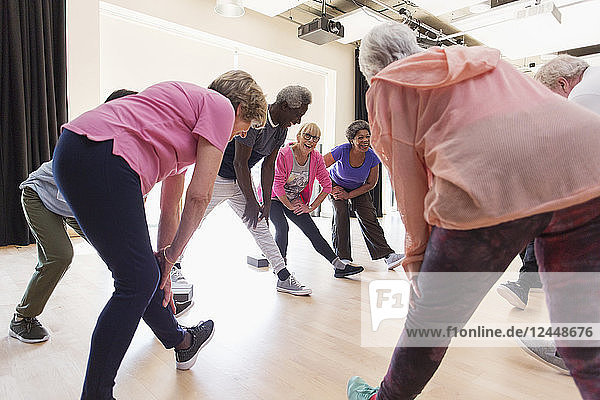 Active seniors stretching legs in exercise class