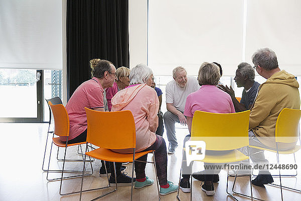 Active seniors talking in circle in community center
