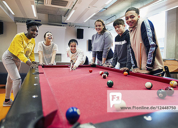 Teenagers playing pool in community center