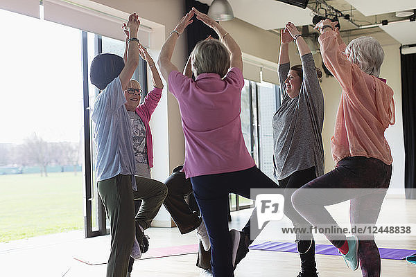 Active senior women exercising  practicing yoga tree pose
