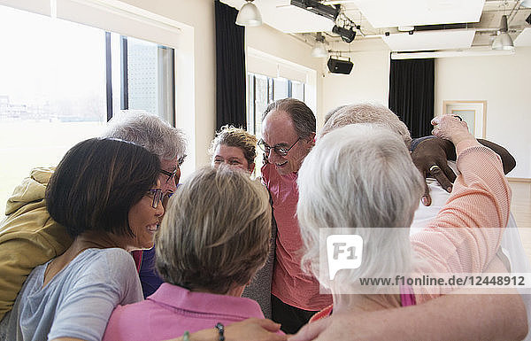 Active seniors hugging in circle huddle