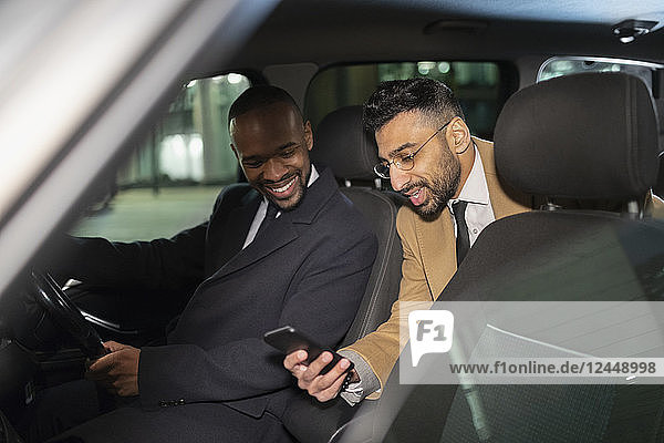 Businessman with smart phone using crowdsourced taxi