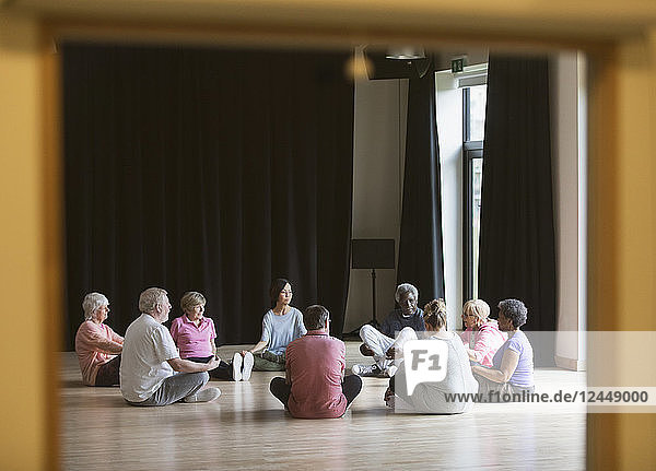 Active seniors meditating in circle