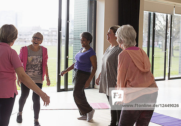 Smiling active senior women talking in exercise class