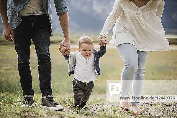 Parents walking with baby son in field