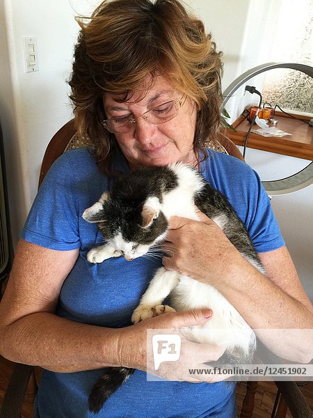 Empathy and concern are writ large on the face of a woman as she holds her pet cat for the last time. The cat was put down the next morning.