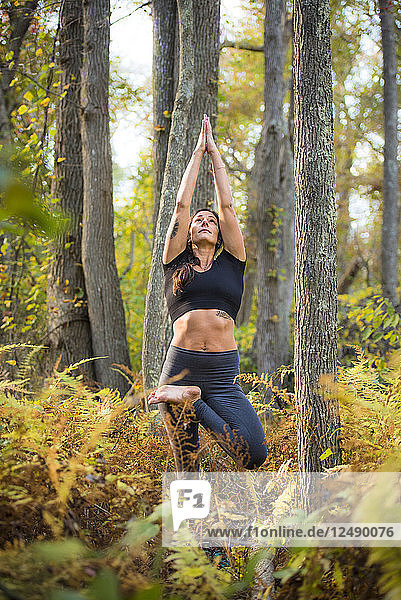 Woman Practicing Yoga In The Forest