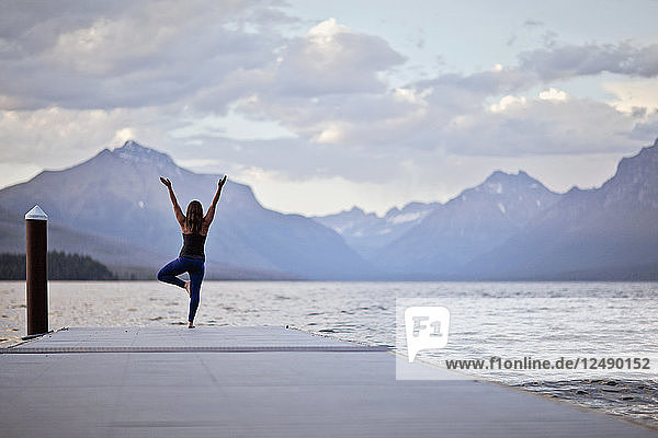 Eine Frau macht Yoga auf einem Steg im Glacier National Park  Montana.