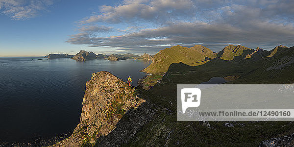 Female hiker on summit of Hornet with panoramic view over Myrland  Flakstad??y  Lofoten Islands  Norway