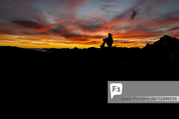 Silhouette Of A Hiker Enjoying The Sunset In The French Alps