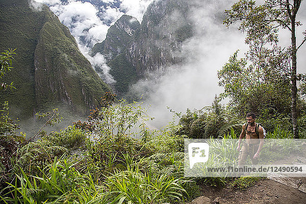 A man hikes the steep path to the ancient site of Machu Pichu in Cusco  Peru.