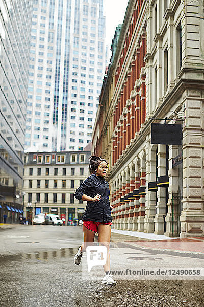 Junge asiatische Mädchen laufen durch die nassen Straßen von Boston