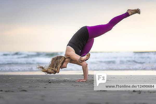 Eine Frau beim Outdoor-Yoga am Strand in Rhode Island