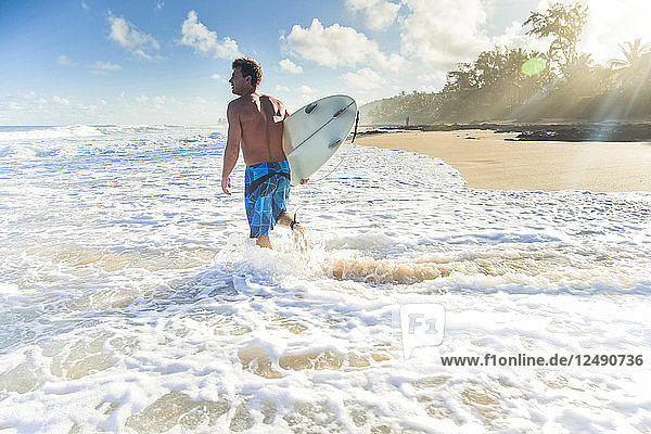 Pancho Sullivan mit seinem Surfbrett auf dem Strand von Rocky Point an der Nordküste von Oahu  Hawaii