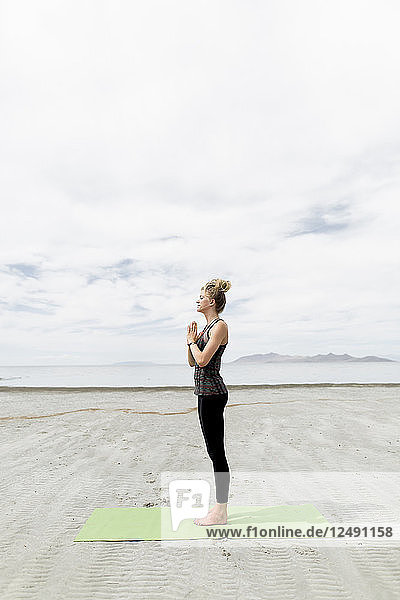 Eine junge Frau  die in der Wüste Yoga macht