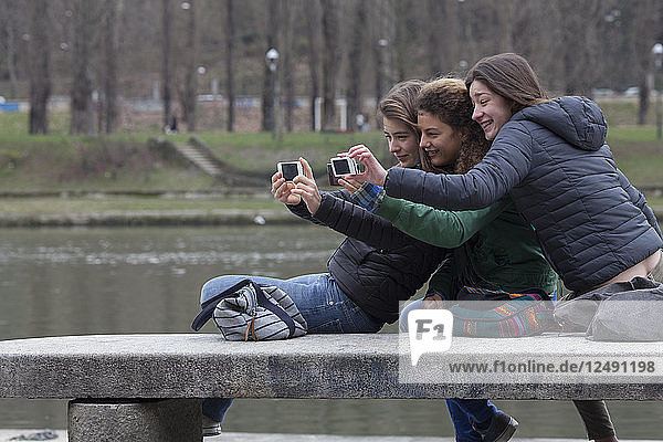 Teenager-Mädchen entspannen sich auf einer Bank und machen ein Selfie