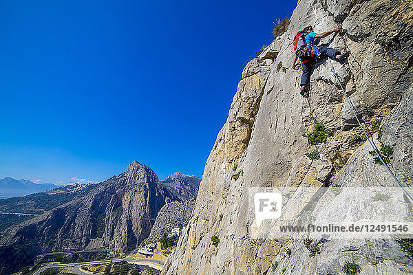 A man lead climbing a route at Sierra de Toix in Spain.
