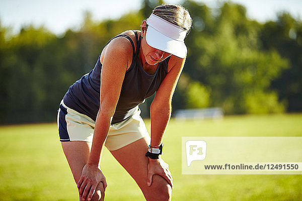 A Female Runner Catches Her Breathe At The Track