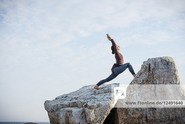 Woman doing yoga on rocks