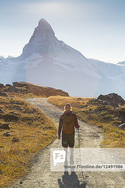 Female Hiker Is Walking In Front Of The Famous Matterhorn