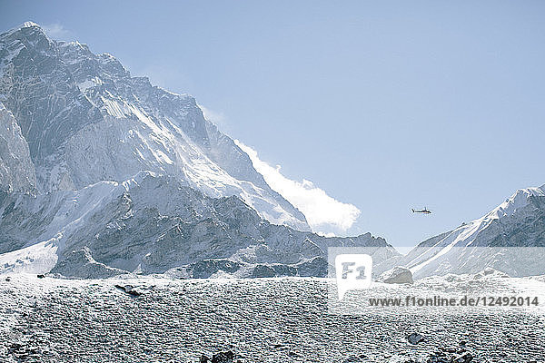 An einem sonnigen Tag im Himalaya kehrt ein Hubschrauber vom Everest Base Camp nach Pheriche zurück.