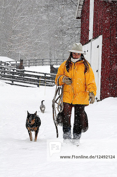 Woman Walking With Her Dog On Snowy Landscape