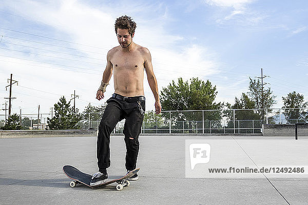 Mann zertritt sein Skateboard und bricht es in zwei Hälften