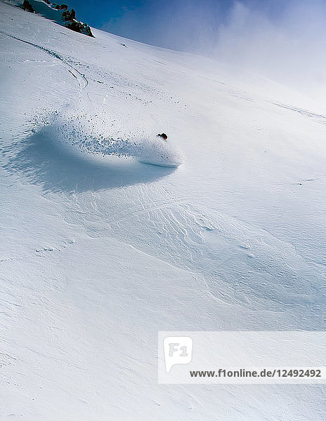 Eine Snowboarderin macht eine Kurve im Tiefschnee am Cerro Catedral  Argentinien