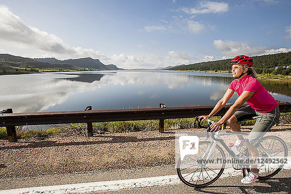 Eine Rennradfahrerin fährt auf ihrem Rennrad südlich der Co Rd 29 am Green Ridge Glad Reservoir.
