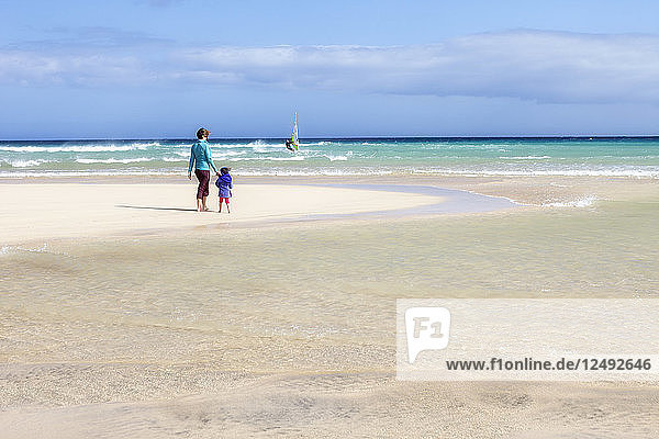 Mutter und Tochter stehend am Strand von Sotovento  Spanien