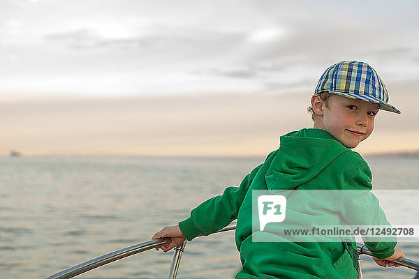 Portrait of young boy on prow of boat