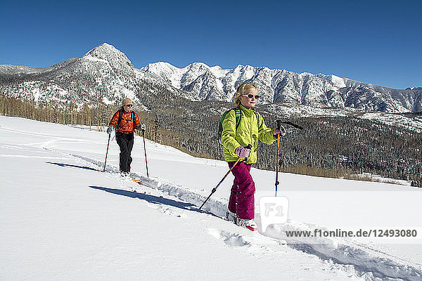 A mother and daughter backcountry skiing above Cascade Creek in the San Juan National Forest  Durango  Colorado.