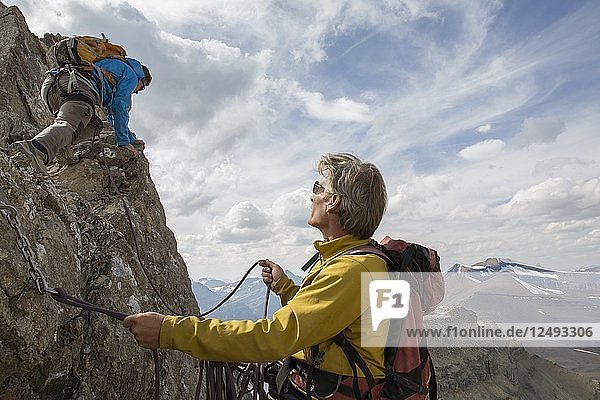 Bergsteiger sichert Teamkollegen auf dem Gipfelgrat
